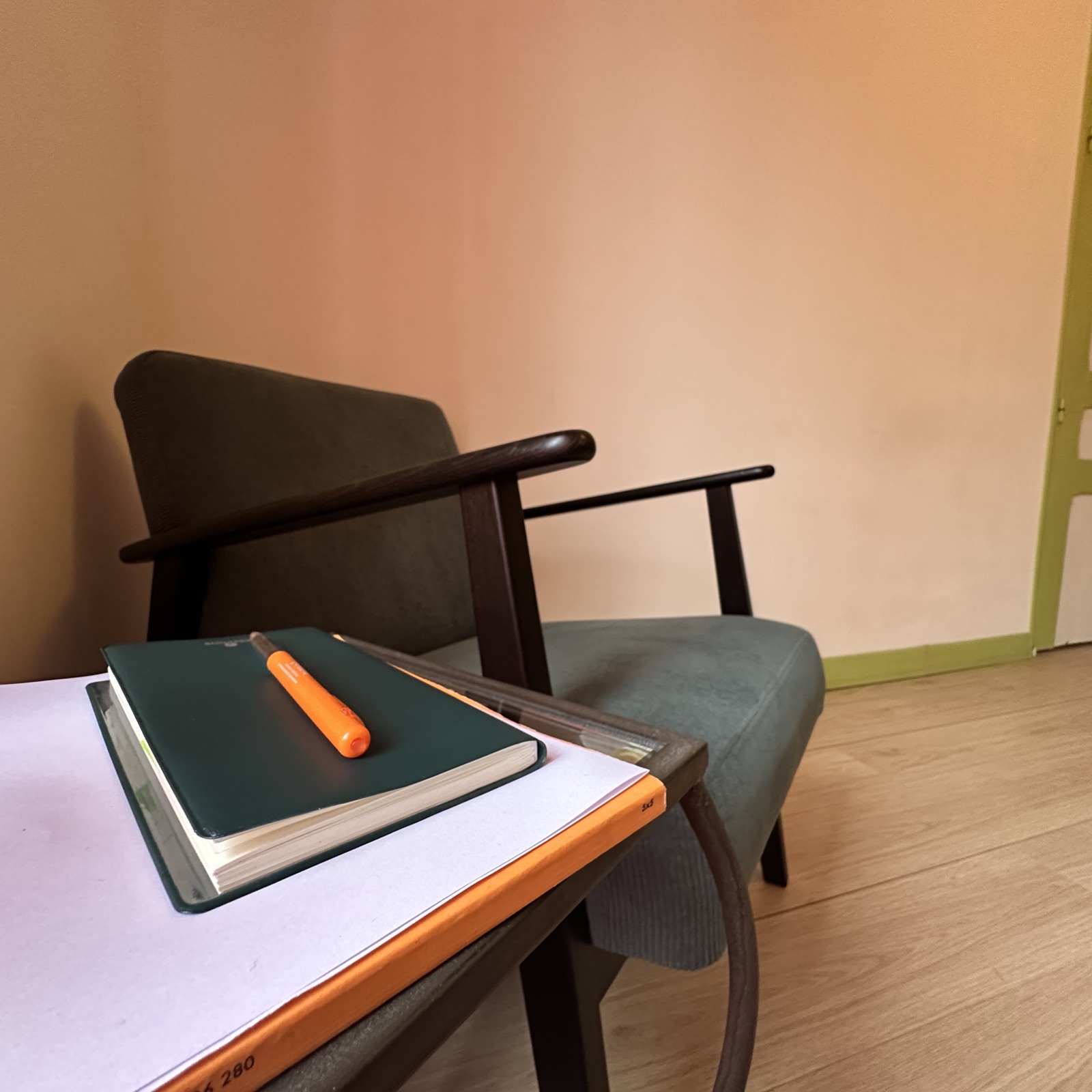 Coin lecture du cabinet, fauteuil et carnets posés