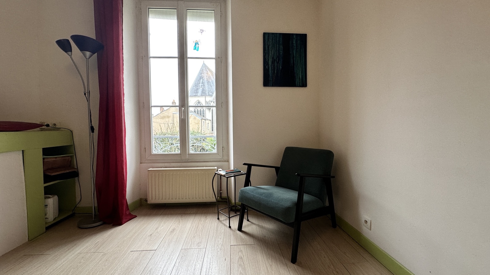 Intérieur du cabinet : fauteuil teal et fenêtre lumineuse